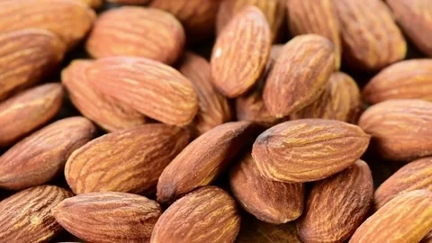 Macro shot of raw organic almonds rotating on a wooden surface Video stock 334572543