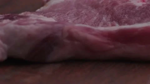 Macro shot of raw pork chop on wooden table Stock Footage 138302453