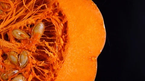 Macro shot of raw pumpkin with seeds rotating on black background in 4K Vídeos de archivo 89891452