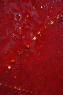 Macro shot of a red background featuring liquid bubbles and blurred lights Stock Photos