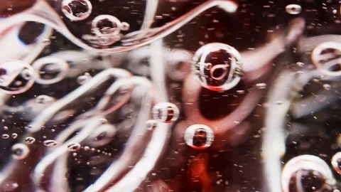 Macro shot of red bubbles being mixed in water Video stock 124671180