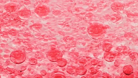 Macro shot of red bubbles in water floating right with yellow background Video stock 124671083