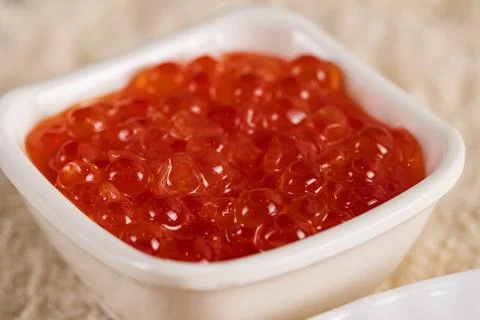 Macro shot of red caviar in small white bowl Stock Photos