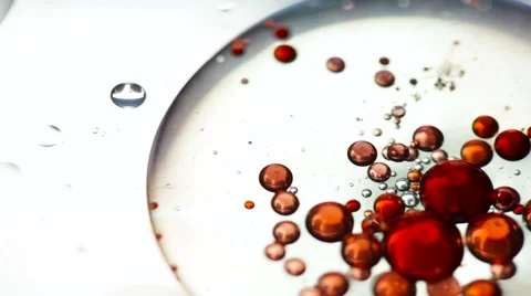 Macro shot of red oil drops and bubbles on water Video stock 55511052