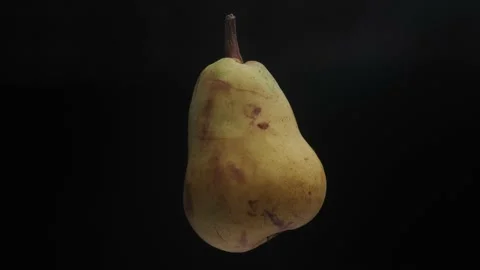 Macro shot of a ripe pear floating on a black background. Stock Footage 142512928