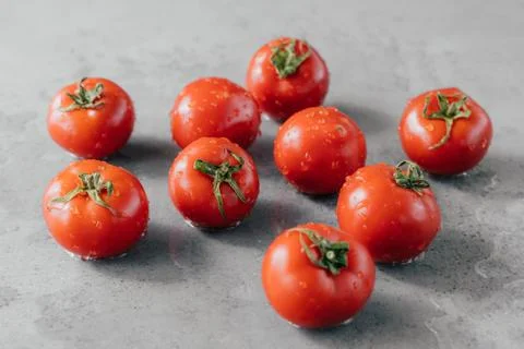 Macro shot of ripe tomatoes with drops of dew just harvested on garden. Organ Foto stock