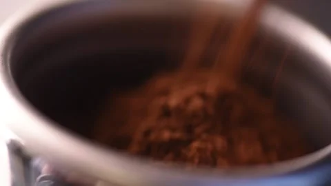 Macro shot of roasted ground coffee beans, sprinkled from a coffee grinder into Stock-Footage 151168743