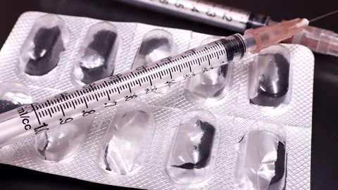 Macro shot of rotating used empty pill blister and syringe. Stock Footage 294596484