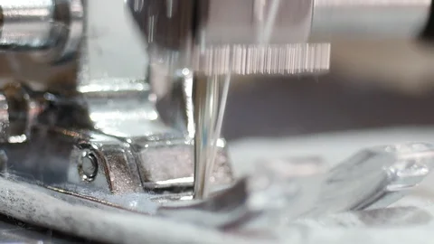 Macro shot of sewing machine mechanic needle sewing fabric. A presser foot is an Stock Footage 126498781