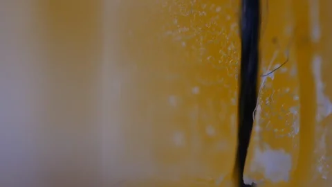 Macro shot of sewing thread &amp; bee wax thread being waxed in bee wax. in terms of Stock Footage 128137827