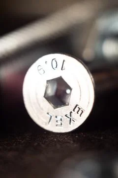 Macro shot of a silver solid screw on the ground with a blurry background 스톡 사진