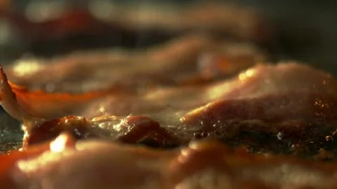 Macro shot of sizzling bacon while being fried. Cooking bacon, closeup view. 스톡 동영상 334641900
