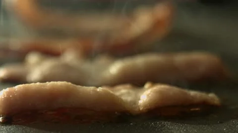 Macro shot of sizzling bacon while being fried. Cooking bacon, closeup view. 스톡 동영상 334641923