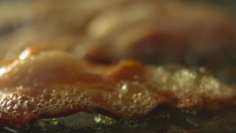 Macro shot of sizzling bacon while being fried. Cooking bacon, closeup view. 스톡 동영상 334641934