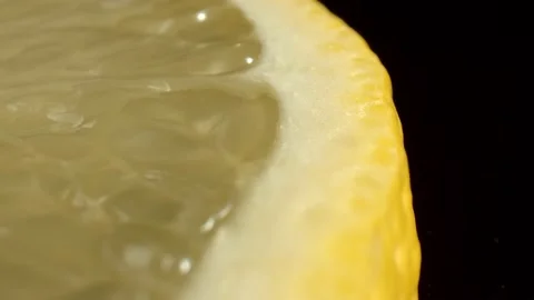 Macro shot of a slice of yellow lemon on the black background. Pulp of citrus Stock Footage 165025457