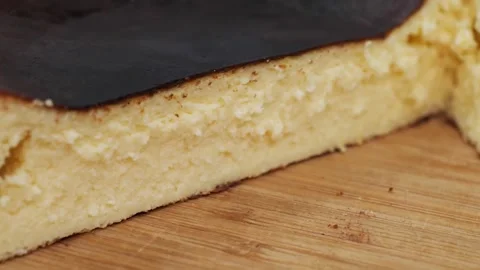 Macro Shot of a Sliced Basque Burnt Cheesecake on a Wooden Board Stock Footage 331777263