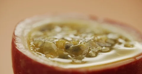 Macro shot of sliced fresh exotic passion fruit fruit rotating on a table Stock Footage 125066816