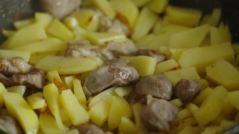 Macro shot of sliced potatoes and meat frying in pan Stock Footage 337046772