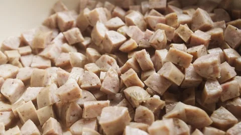 Macro shot of small chopped pieces of sausage sizzling and browning in a frying Vídeos de archivo 347102180