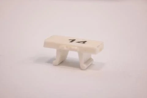 Macro shot of a small white plastic cable marker labeled with the number Foto stock