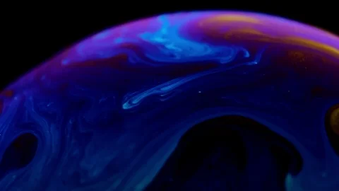 Macro shot of a soap bubble creates a colorful and black background Stock Footage 114707996