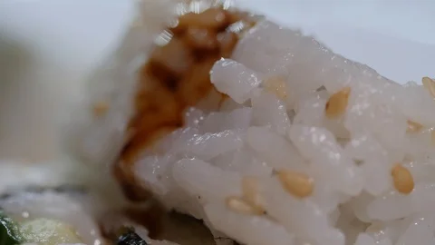 Macro shot of soy sauce dripping onto the outer edge of rice on a sushi Video stock 120210985