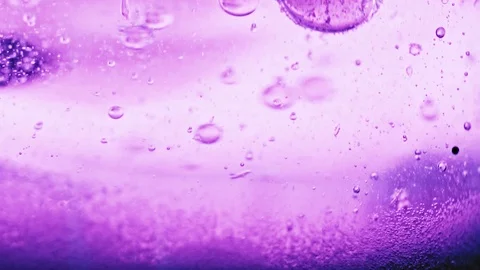 Macro shot of sparkling violet bubbles falling to ground in bright violet Video stock 124671105