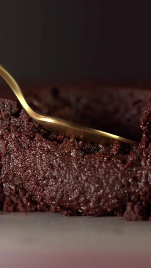 Macro shot of a spoon pressing gliding into a soft chocolate brownie Stock Footage 332084562