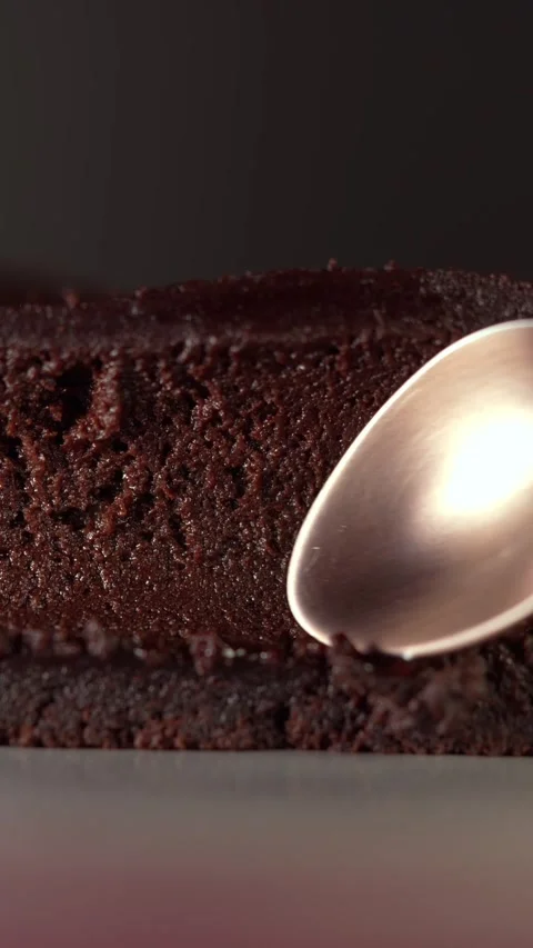 Macro shot of a spoon pressing gliding into a soft chocolate brownie Stock Footage 332084572