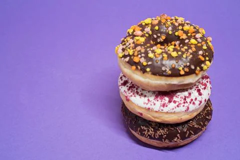 Macro shot of stack of donuts over purple background 스톡 사진