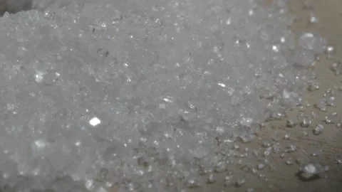 Macro shot of sugar cane crystals on a wood board while a knife is used to colle Stock Footage 139426252