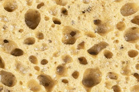 Macro shot of a surface of plastic yellow sponge background. Close-up textu.. Stock Photos