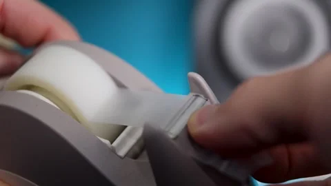 Macro shot of tape being cut into smaller sections from a sellotape holder Stock Footage 299674703