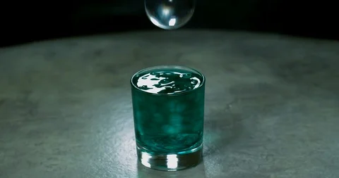 Macro shot of teal marbles spilling out of glass cup Stock Footage 117148614
