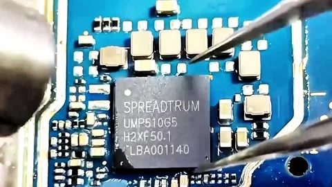 Macro Shot of Technician Holding Spreadtrum UMP510G5 IC Chip with Tweezers Stock Footage 332981141