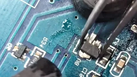 Macro Shot of Technician Soldering Micro Component on Blue Circuit Board Stock Footage 333610577