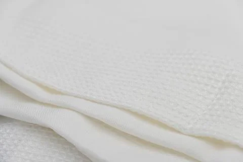 Macro shot texture of folded white towel kitchen fabric for background design Stock Photos