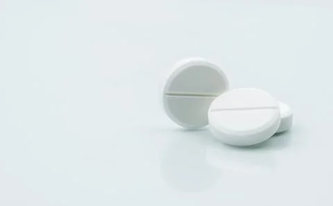Macro shot of three white chewable tablets on white background with shadows.  Stock-Fotos