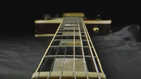 Macro shot through a laid down electric guitar Stock Footage 130543956