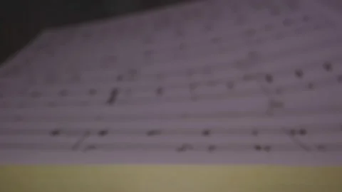 Macro shot through musical notes on a music book page Vidéo 130413295