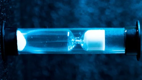 Macro shot of a time lapse of an hourglass, white sand drops, footage ideal to Stockbeeldmateriaal 101680199