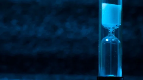 Macro shot of a time lapse of an hourglass, white sand drops, footage ideal to Video stock 101680647