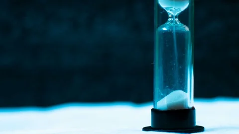 Macro shot of a time lapse of an hourglass, white sand drops, footage ideal to Stock Footage 101681943