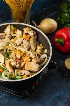 Macro shot top view of pan with fragrant frying meat and mix of vegetables on Stock Photos