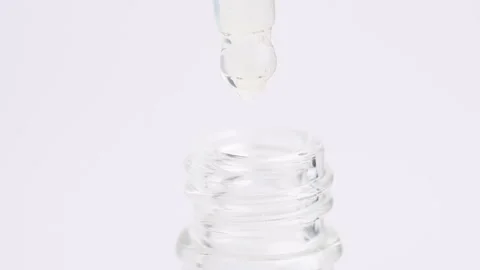 Macro shot of transparent moisturizing serum lotion in pipette falling in t.. Stock Footage 261534316