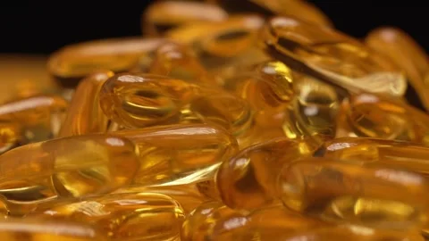 Macro shot turn table rotation of gelatin capsules omega 3 fish oil pills Stock Footage 263743823