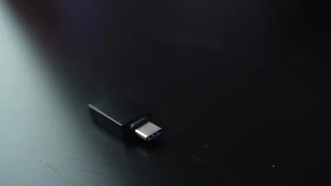 Macro shot of a USB-C to USB 3.0 adapter on a dark desk with shallow depth of Stock Footage 328974771