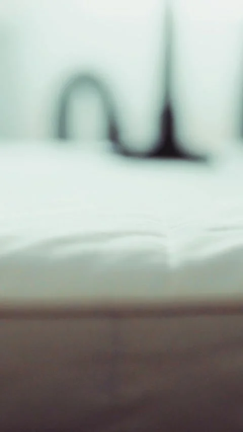 A macro shot of a vacuum cleaner brushing over a white mattress 動画素材 341858596