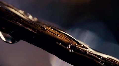 Macro shot of a vanilla essence drop sliding over a closed vanilla pod with Stock Footage 308370209