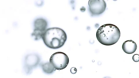 Macro shot of various air bubbles in water rising in slow motion Stock Footage